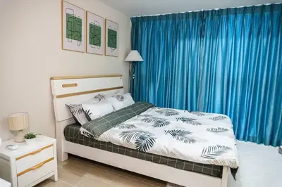 a bedroom with a bed and a blue curtain at A2J Luxury 3BR Uptown Balcony BGC Suite Near Mall in Manila