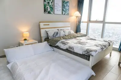 a bedroom with a white bed and a window at A2J Luxury 3BR Uptown Balcony BGC Suite Near Mall in Manila