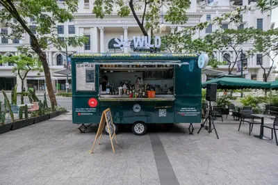 a green food truck parked in front of a building at Uptown Parksuites Modern Room in Manila