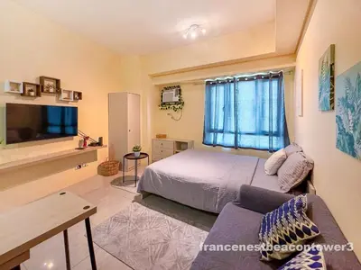 a bedroom with a bed and a couch and a tv at Modern Condo Living in Makati in Manila