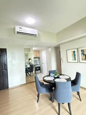 a living room with a table and chairs at Spacious BGC 2 BR with a view in Manila