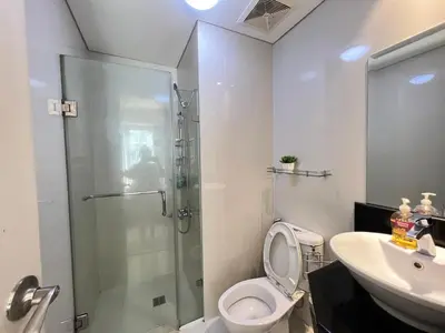 a bathroom with a shower and a toilet and a sink at Condotel Across Naia Airport with WIFI in Manila