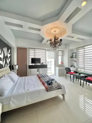 a bedroom with a large bed and a dining room at Condotel Across Naia Airport with WIFI in Manila