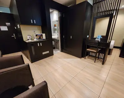 a living room with a table and a mirror at Green Glass Hotel in Calamba