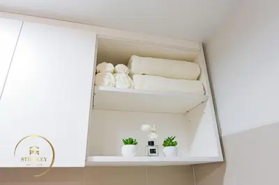 a shelf in a bathroom with towels and plants at MOA Shore 3 New Modern One bedroom Condo in Manila