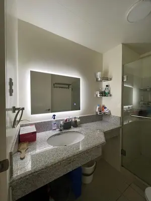 a bathroom with a sink and a mirror at Lumiere suites in Manila
