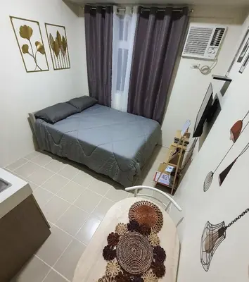 a room with a bed and a table in it at Urban Deca Shaw EDSA Mandaluyong in Manila