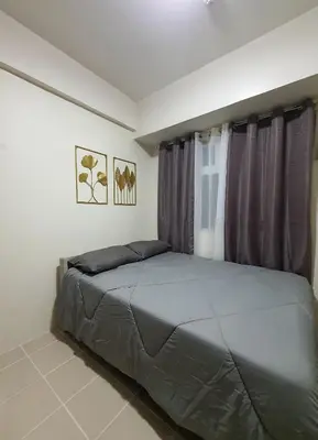 a bedroom with a large bed with purple curtains at Urban Deca Shaw EDSA Mandaluyong in Manila