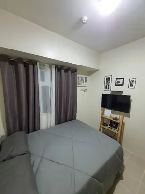 a bedroom with a large bed and a television at Urban Deca Shaw EDSA Mandaluyong in Manila