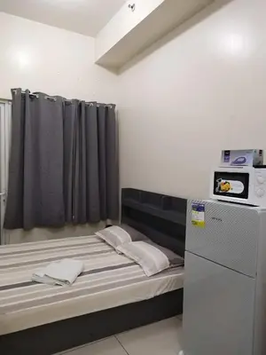 a small room with a bed and a microwave at SMDC Breeze Residences in Manila
