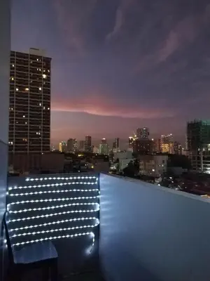a view of a city skyline at night with a bench at SMDC Breeze Residences in Manila