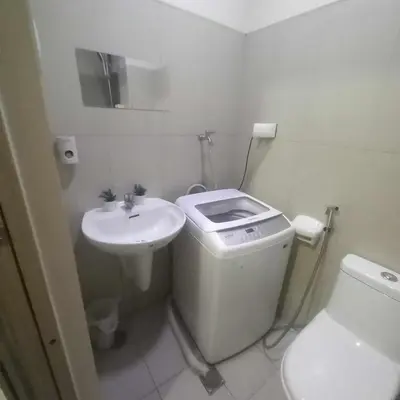 a white bathroom with a sink and a toilet at SMDC Breeze Residences in Manila
