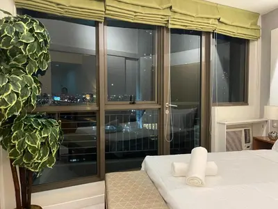 a bedroom with a large window with a view of a city at Fabulous Skyline KL Greenbelt Makati in Manila