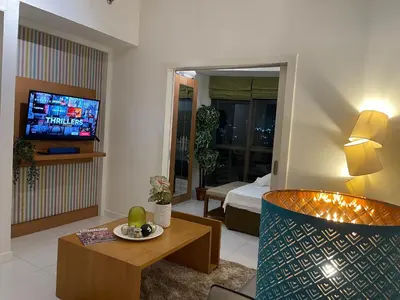 a living room with a couch and a tv in a room at Fabulous Skyline KL Greenbelt Makati in Manila