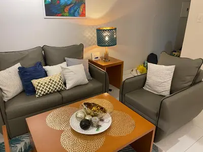 a living room with two couches and a coffee table at Lux Skyline KL Greenbelt, Isabel's Makati Rooms in Manila
