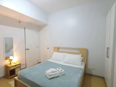 a bedroom with a bed with two towels on it at Avant in BGC - Spacious 1 Bedroom with Amazing View in Manila