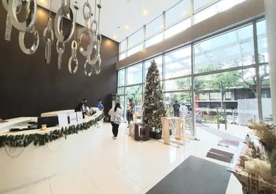 a christmas tree in a mall with people walking in the lobby at Avant in BGC - Spacious 1 Bedroom with Amazing View in Manila