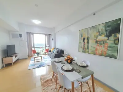 a living room with a white table and a couch at Avant in BGC - Spacious 1 Bedroom with Amazing View in Manila