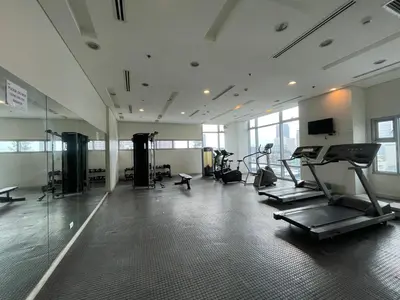 a gym with treadmills and machines in a room at Cozy Condo in Ermita Manila near St Lukes Medical Center and US Embassy in Manila