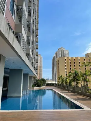 a swimming pool in the middle of a building with tall buildings at Cozy Condo in Ermita Manila near St Lukes Medical Center and US Embassy in Manila