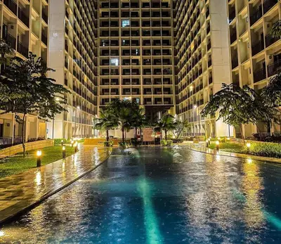 a wet street in a city at night with buildings at SHORE RESIDENCE D13 shortwalk Mall of asia near airport in Manila