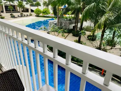 a view of the pool from the balcony of a resort at SHORE RESIDENCE D13 shortwalk Mall of asia near airport in Manila