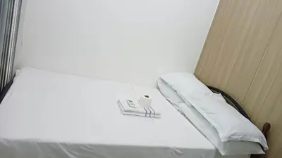 a bed with white sheets and a white pillow at SHORE RESIDENCE D13 shortwalk Mall of asia near airport in Manila