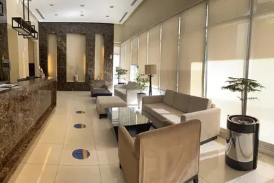 a lobby with couches and chairs and a table at 1 Bedroom Bayview Condo near SLMEC & US Embassy in Manila