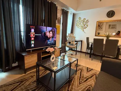 a living room with a large flat screen tv at 1 Bedroom Bayview Condo near SLMEC & US Embassy in Manila