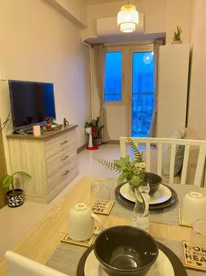 a dining room with a table and a television at SMDC Coast Residences Condo near MOA, CCP, PICC, Star City in Manila