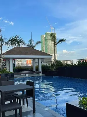 a swimming pool with tables and chairs and a building at SMDC Coast Residences Condo near MOA, CCP, PICC, Star City in Manila