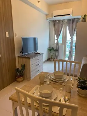 a dining room with a table and a television at SMDC Coast Residences Condo near MOA, CCP, PICC, Star City in Manila