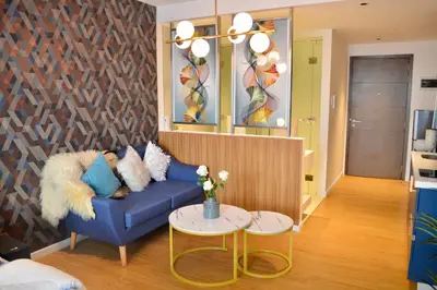 a living room with a blue couch and a table at Luxxe interior design condo - Residences at Acqua private residences in Manila