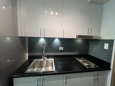 a kitchen with a sink and white cabinets at MiamiViceLuxuryStays at Shore2 in Manila