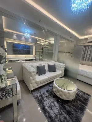 a living room with a white couch and a coffee table at MiamiViceLuxuryStays at Shore2 in Manila