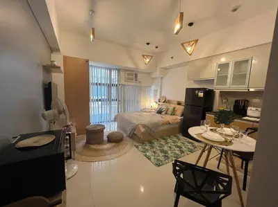 a large living room with a bed and a kitchen at Cozy Studio Viceroy Residences McKinley Hill Bgc in Manila