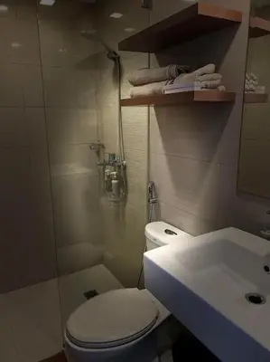 a bathroom with a white toilet and a sink at Cozy Studio Viceroy Residences McKinley Hill Bgc in Manila