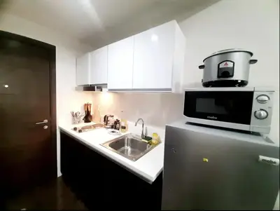 a kitchen with a sink and a microwave at Air Residence Makati in Manila