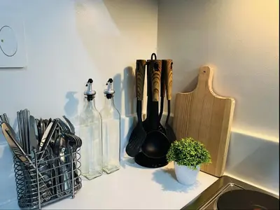 a kitchen counter with some utensils and bottles on it at Air Residence Makati in Manila