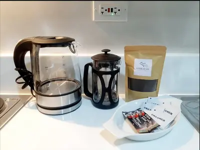 a counter with a coffee maker and a tea kettle at Air Residence Makati in Manila