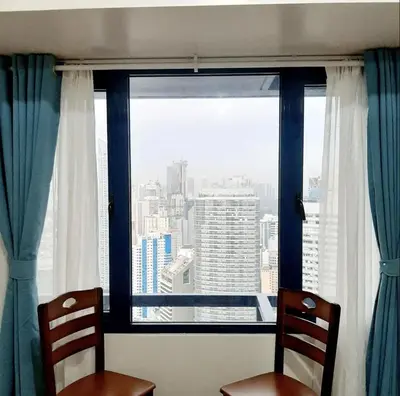 two chairs in front of a window with a view at Air Residence Makati in Manila