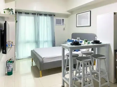 a room with a bed and a table and stools at Modern and homely Condo in Shaw Boulevard in Manila
