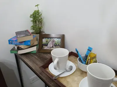a table with two cups and a picture on it at Home at Last, 1 Bedroom Pool View with Balcony in Manila