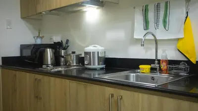 a kitchen counter with a sink and a microwave at Home at Last, 1 Bedroom Pool View with Balcony in Manila