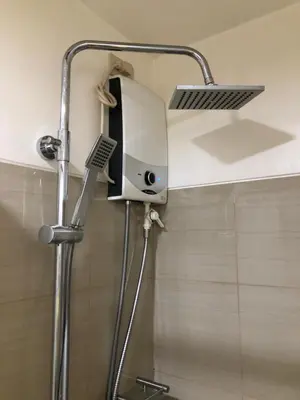a shower with a shower head in a bathroom at Home at Last, 1 Bedroom Pool View with Balcony in Manila