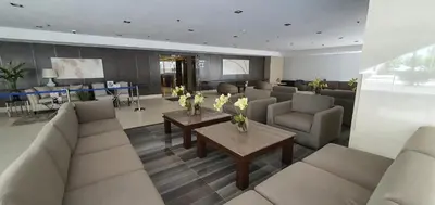 a living room with couches and a table with flowers at Home at Last, 1 Bedroom Pool View with Balcony in Manila