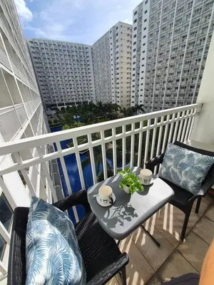 a balcony with a table and chairs on a balcony at Home at Last, 1 Bedroom Pool View with Balcony in Manila