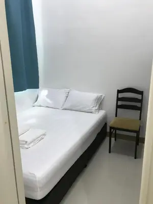 a bed and a chair in a room at South Residences staycation in Manila