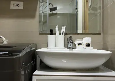 a white sink in a bathroom with a mirror at Victoria Suite at Shore Residences in Manila
