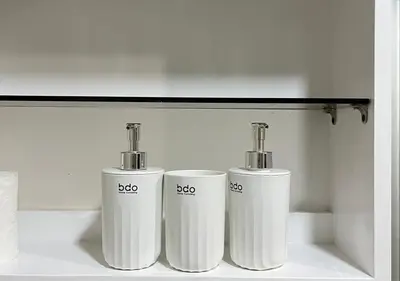 three white cylinders are sitting on a shelf at Victoria Suite at Shore Residences in Manila